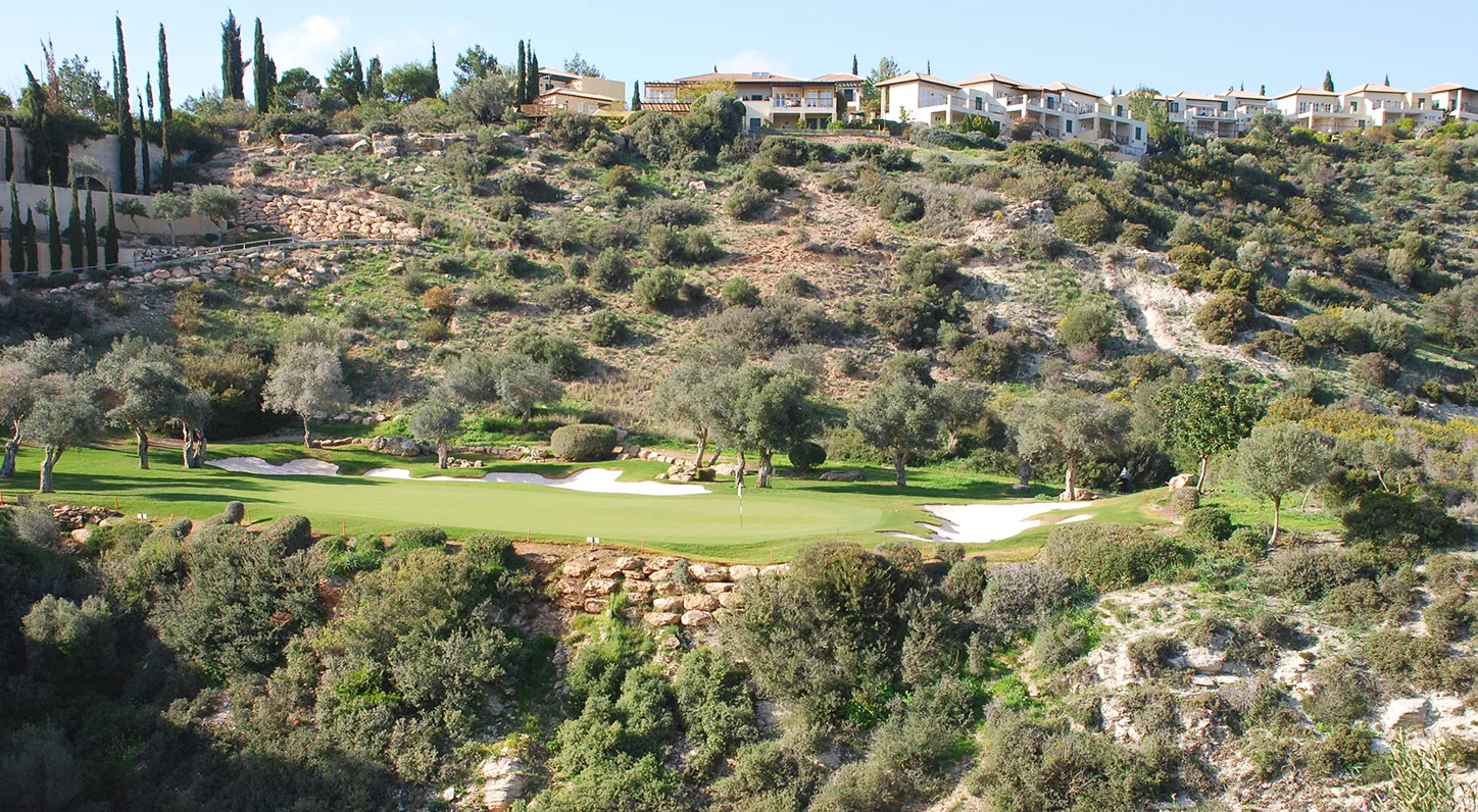 View of the 7th hole on Aphrodite Hills PGA National Golf Course, with properties on the hill above.