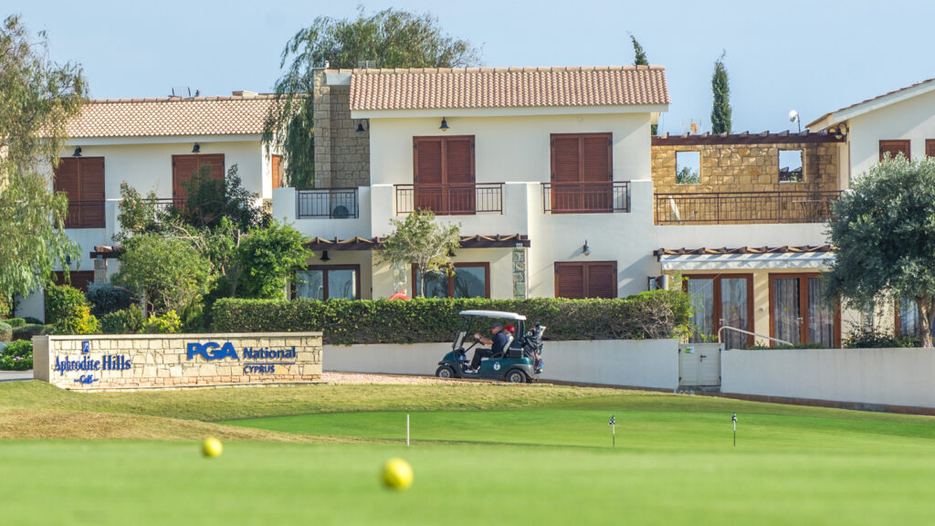 Looking at a villa on Hestiades Greens from the putting green at Aphrodite Hills Golf Club, with buggy and balls in sight.