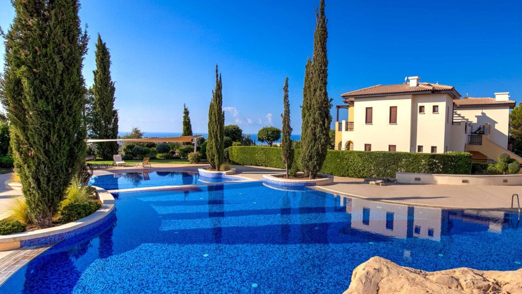 View of Orpheus Village communal pool on Aphrodite Hills Resort, Cyprus, with sea views.
