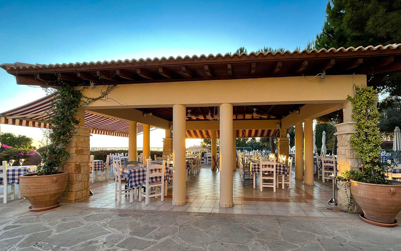 To Pithari Tavern restaurant on Aphrodite Hills, tables set up at sunset. Cyprus.