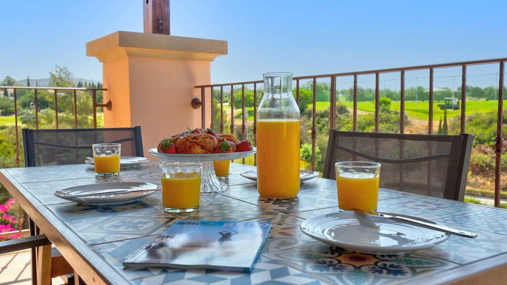 Breakfast set up on table overlooking golf driving range on Aphrodite Hills Resort, Cyprus.