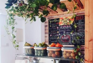 Shop counter with boxes of fruit and menu board behind. Meraki Restaurant in Paphos.