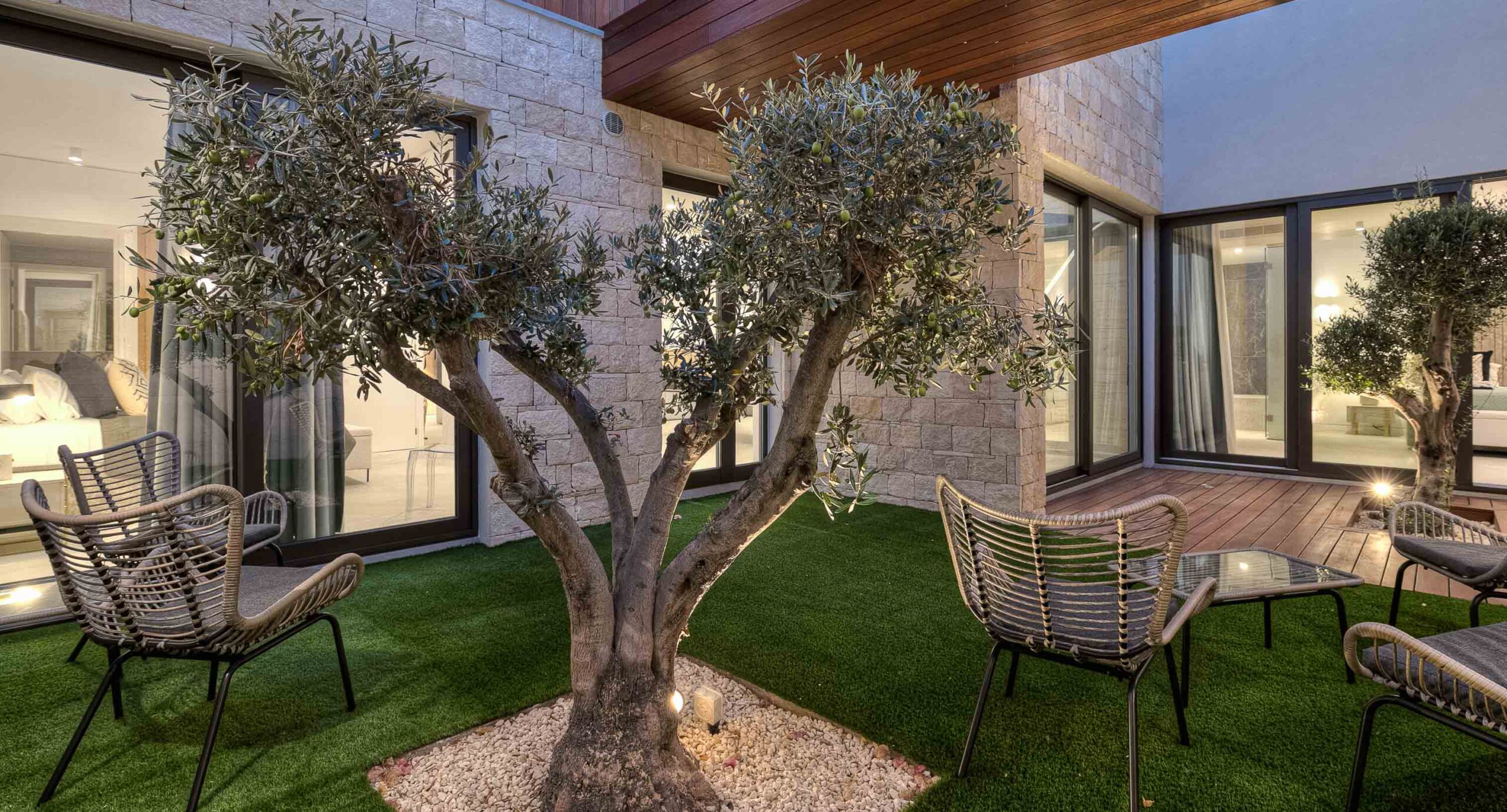Photo of Villa 286 on Aphrodite Hills - outside terrace with olive trees, lit up in dusk